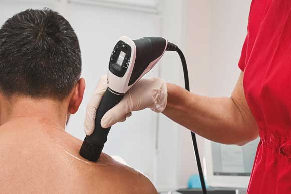 Patient doing Shockwave Therapy at San Ramon Auto Accident Injury Clinic in San Ramon after an auto accident resulting in whiplash